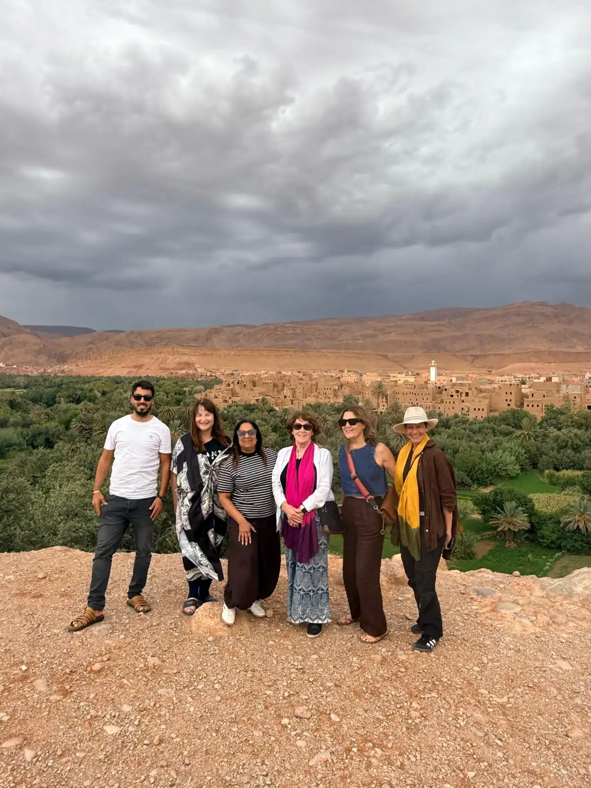 Travelers with their guide on the 5 days desert tour from Marrakech, overlooking the Tinghir palm grove and kasbah village