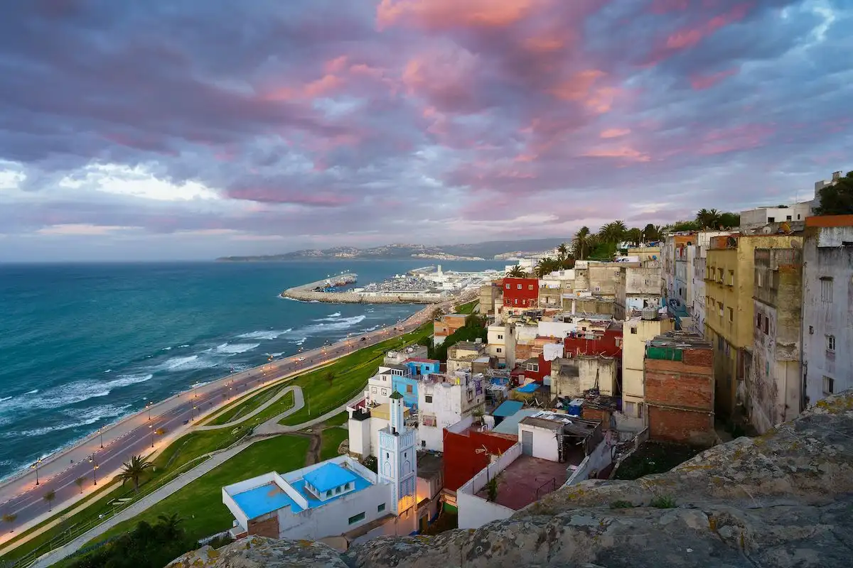 Is Tangier safe for tourists? White medina houses cascading down a hillside toward the Mediterranean coastline in Tangier, Morocco