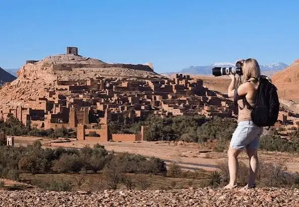 Traveler photographing a Moroccan kasbah, a highlight on Morocco road trips near Todra Gorge