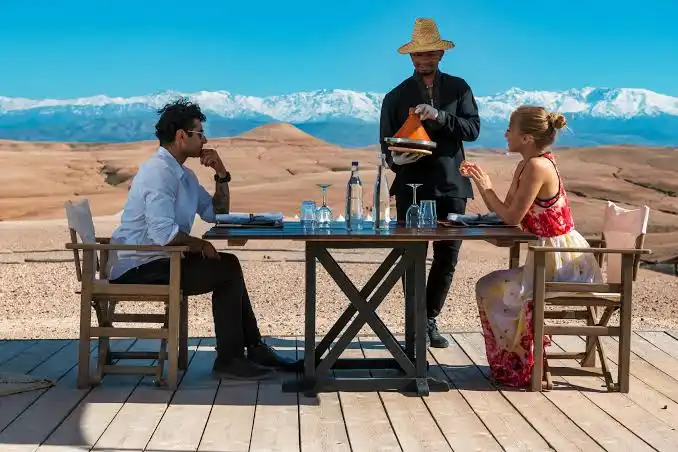 Couple enjoying a private desert dinner with mountain views on a Morocco Tours from Canada