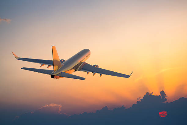 is it better to land in Marrakech or Casablanca?. Airplane flying at sunset, representing the choice between landing in Marrakech or Casablanca in Morocco