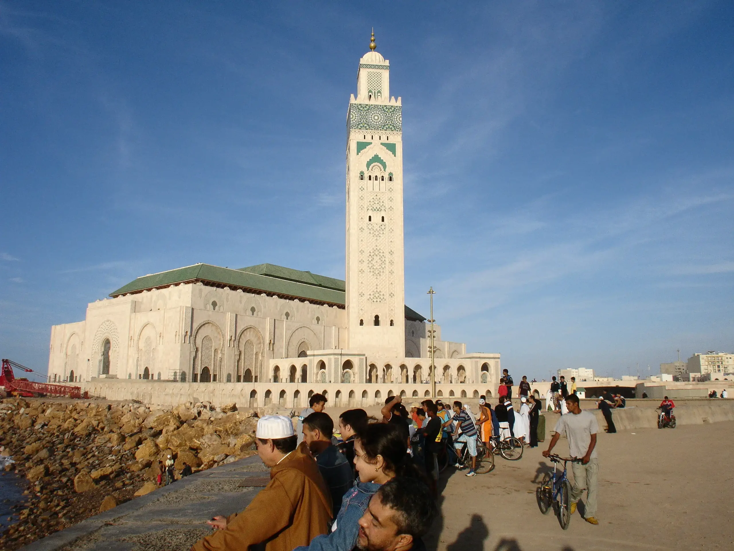 Is Casablanca Safe? Hassan II Mosque in Casablanca, a top pick for things to do in Casablanca, with people gathered by the ocean at sunset